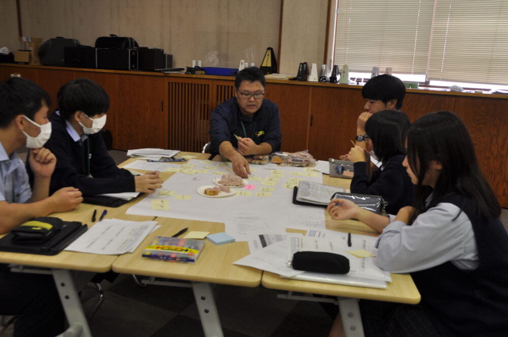 ワークショップ 企業さんから既成商品の説明を受けている